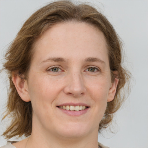 Joyful white young-adult female with medium  brown hair and blue eyes