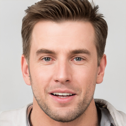 Joyful white young-adult male with short  brown hair and grey eyes