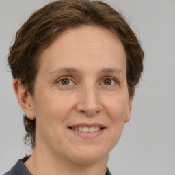 Joyful white adult female with medium  brown hair and grey eyes