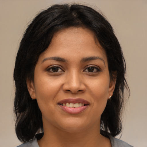 Joyful latino young-adult female with medium  brown hair and brown eyes