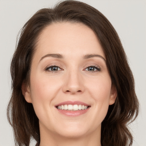 Joyful white young-adult female with medium  brown hair and grey eyes