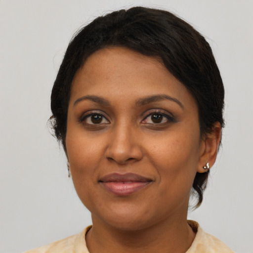 Joyful black young-adult female with short  brown hair and brown eyes