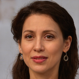 Joyful white adult female with long  brown hair and brown eyes