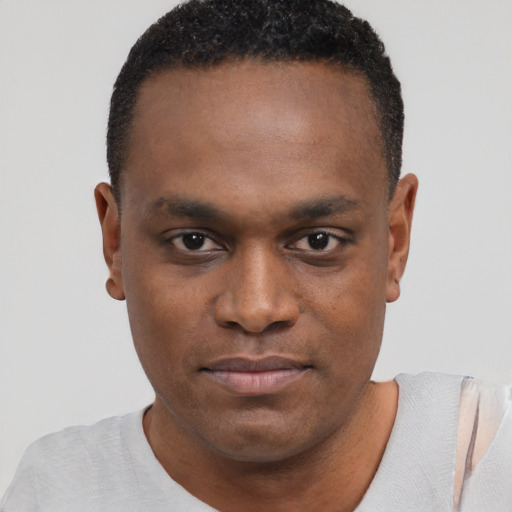 Joyful black young-adult male with short  brown hair and brown eyes