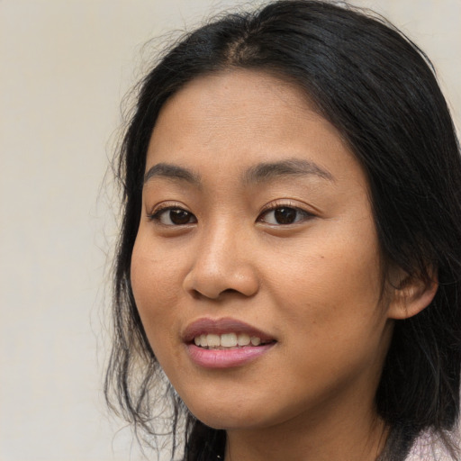 Joyful asian young-adult female with long  brown hair and brown eyes