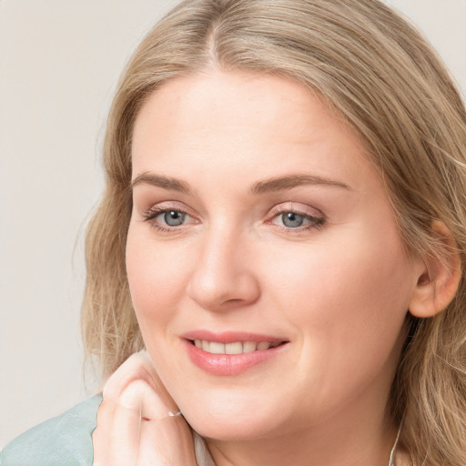 Joyful white young-adult female with long  brown hair and blue eyes