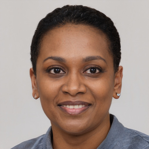 Joyful black young-adult female with short  black hair and brown eyes