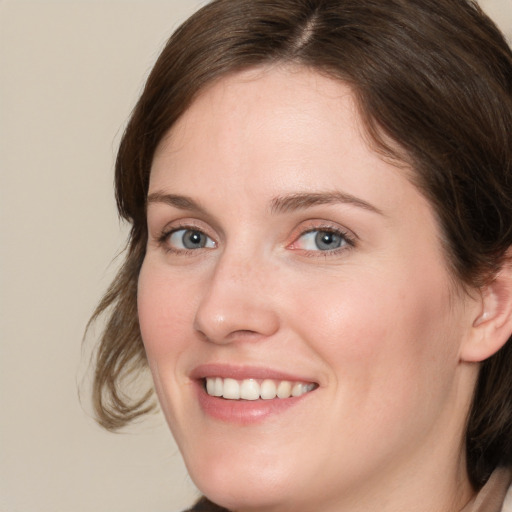 Joyful white young-adult female with medium  brown hair and blue eyes