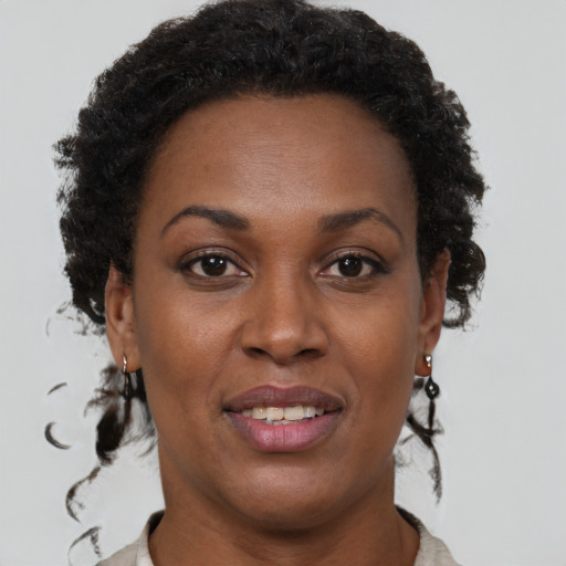 Joyful black young-adult female with short  brown hair and brown eyes