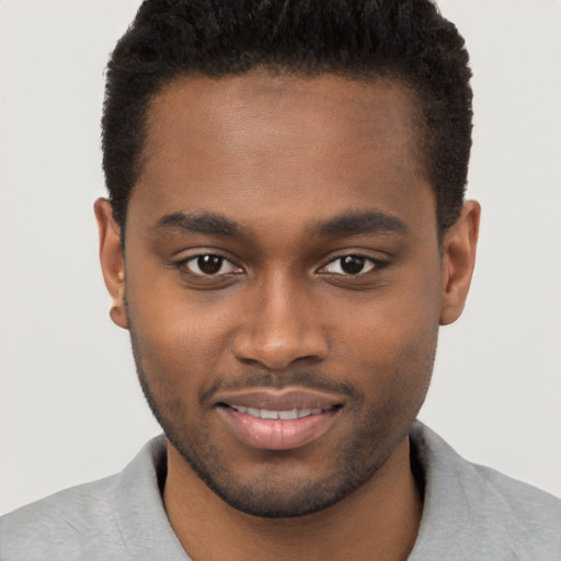 Joyful black young-adult male with short  brown hair and brown eyes