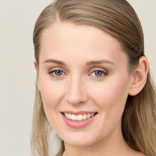 Joyful white young-adult female with long  brown hair and blue eyes