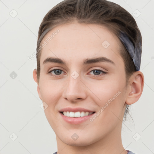 Joyful white young-adult female with short  brown hair and grey eyes