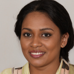 Joyful black young-adult female with medium  brown hair and brown eyes