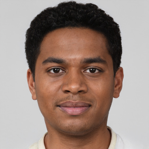 Joyful black young-adult male with short  black hair and brown eyes