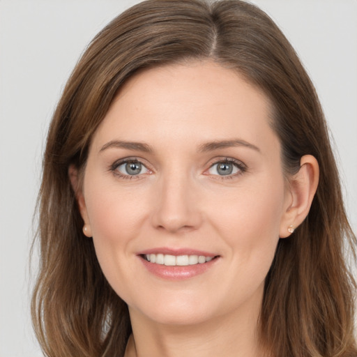 Joyful white young-adult female with long  brown hair and grey eyes