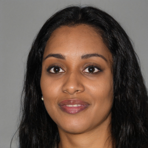 Joyful black young-adult female with long  black hair and brown eyes