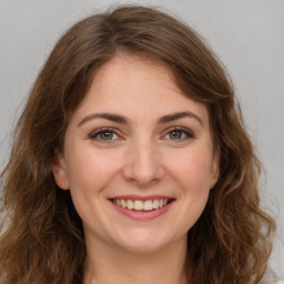 Joyful white young-adult female with long  brown hair and green eyes