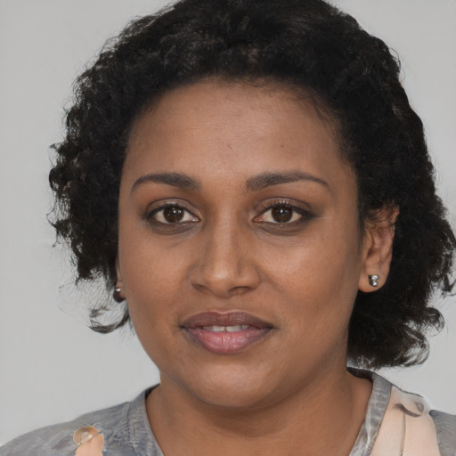 Joyful black young-adult female with medium  black hair and brown eyes