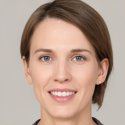 Joyful white young-adult female with medium  brown hair and grey eyes