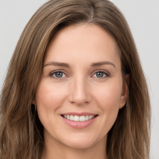 Joyful white young-adult female with long  brown hair and green eyes