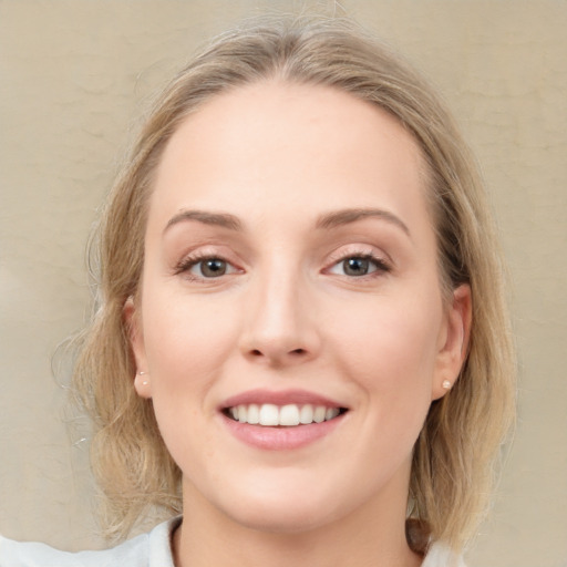 Joyful white young-adult female with medium  brown hair and blue eyes