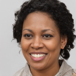 Joyful black adult female with long  brown hair and brown eyes