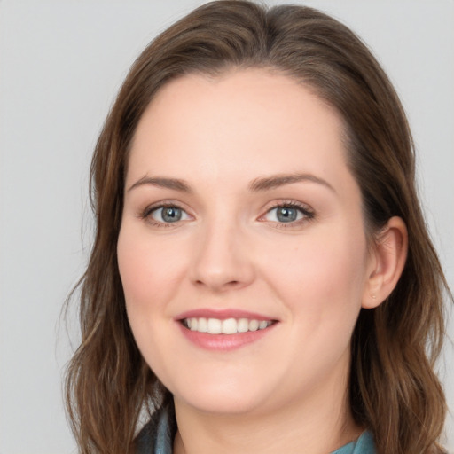 Joyful white young-adult female with long  brown hair and blue eyes