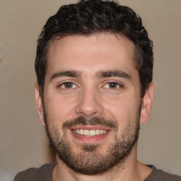 Joyful white young-adult male with short  black hair and brown eyes