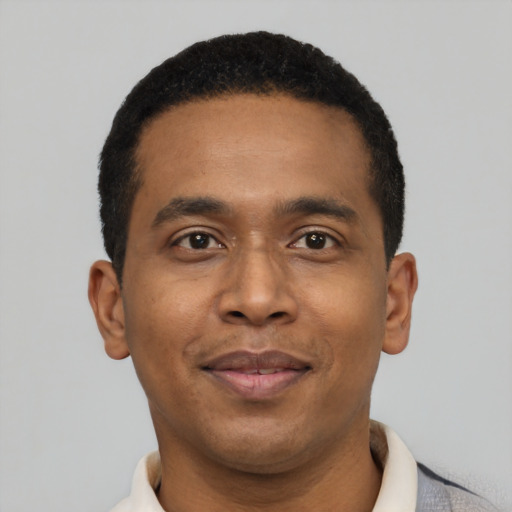 Joyful black young-adult male with short  black hair and brown eyes