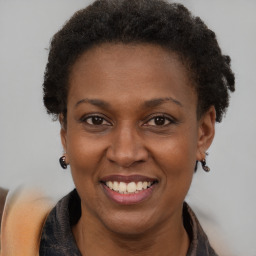 Joyful black adult female with short  brown hair and brown eyes