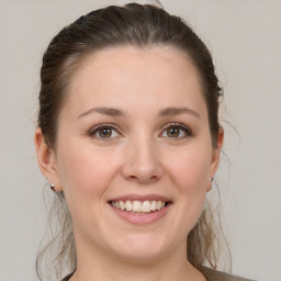 Joyful white young-adult female with medium  brown hair and grey eyes