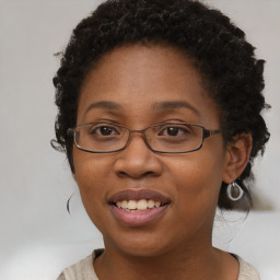 Joyful black adult female with medium  brown hair and brown eyes