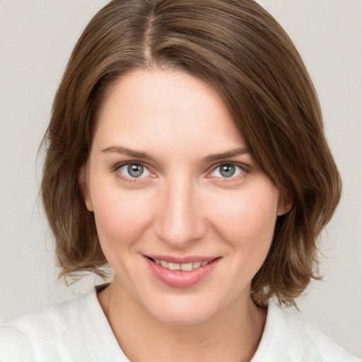 Joyful white young-adult female with medium  brown hair and green eyes