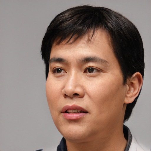 Joyful asian young-adult male with short  black hair and brown eyes