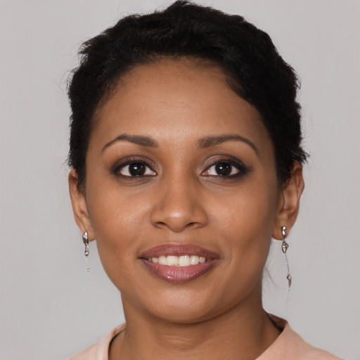 Joyful black young-adult female with short  brown hair and brown eyes