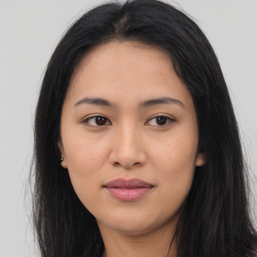 Joyful latino young-adult female with long  brown hair and brown eyes