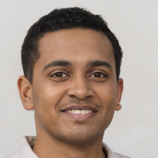 Joyful latino young-adult male with short  brown hair and brown eyes