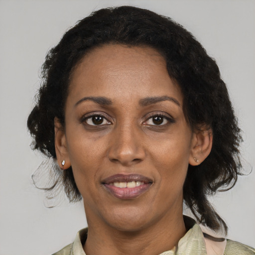 Joyful black adult female with medium  black hair and brown eyes