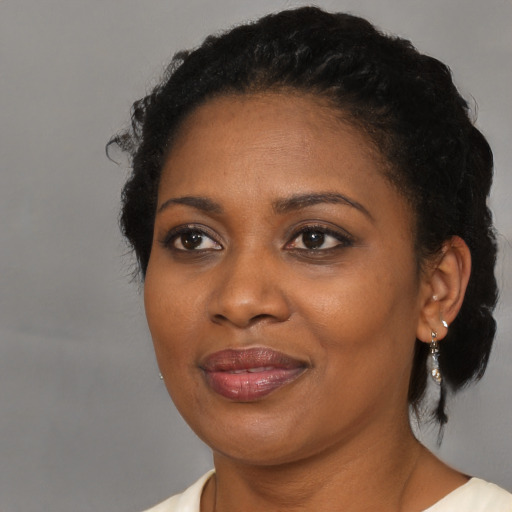 Joyful black adult female with long  brown hair and brown eyes