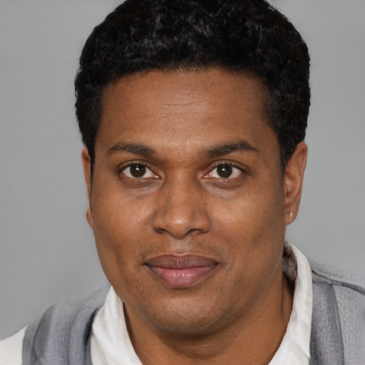Joyful latino adult male with short  black hair and brown eyes