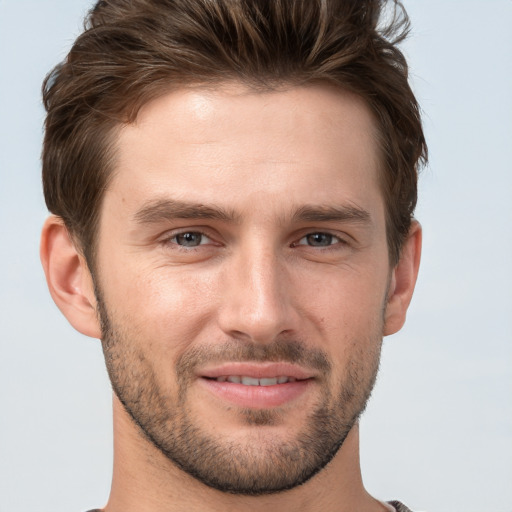 Joyful white young-adult male with short  brown hair and grey eyes