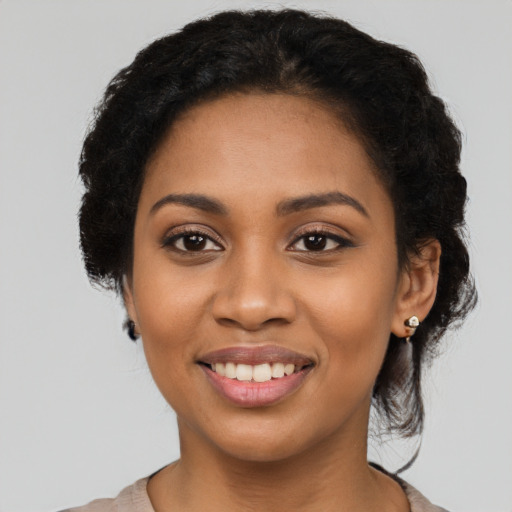 Joyful black young-adult female with short  black hair and brown eyes