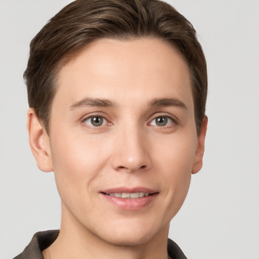 Joyful white young-adult male with short  brown hair and grey eyes