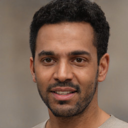 Joyful latino young-adult male with short  black hair and brown eyes