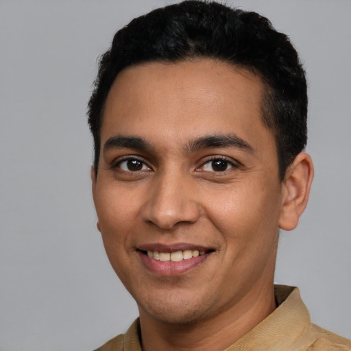 Joyful latino young-adult male with short  black hair and brown eyes