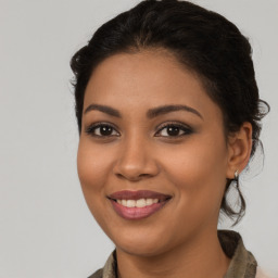 Joyful latino young-adult female with medium  brown hair and brown eyes