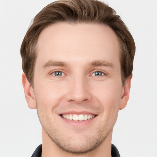 Joyful white young-adult male with short  brown hair and grey eyes