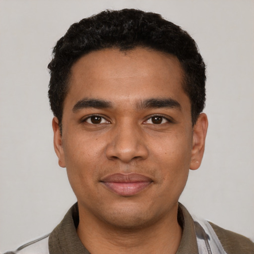 Joyful black young-adult male with short  black hair and brown eyes