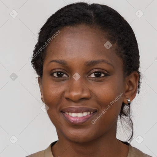 Joyful black young-adult female with long  brown hair and brown eyes