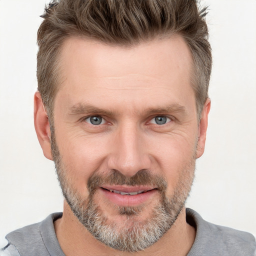 Joyful white adult male with short  brown hair and grey eyes